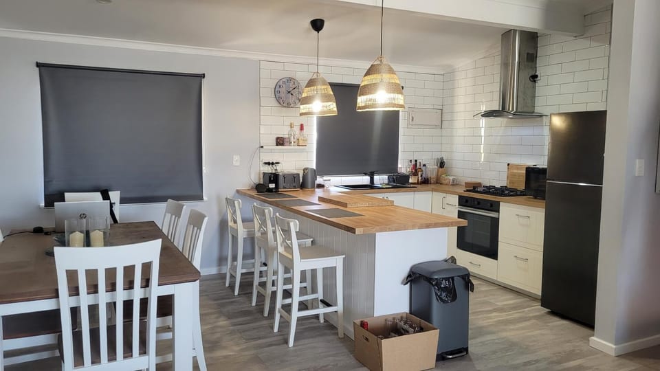Modern kitchen and dining area inside Kalbarri Sunset Villa with timber finishes and pendant lighting