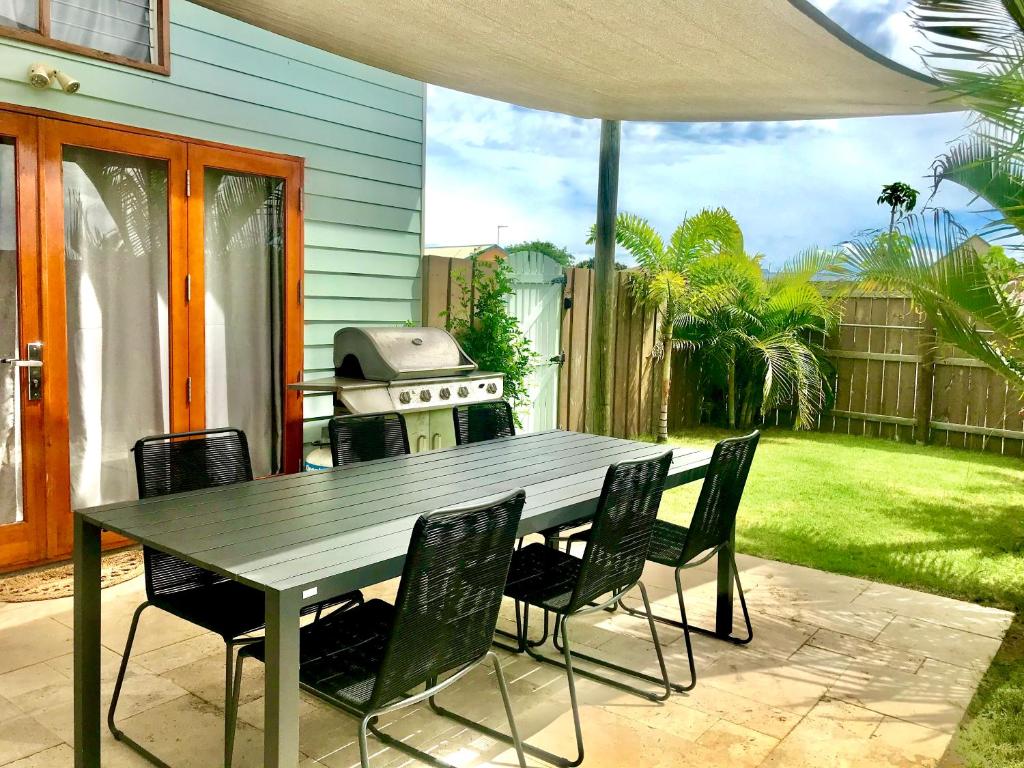 Salty Blue Holiday Home Kalbarri outdoor dining area with BBQ and lush garden.