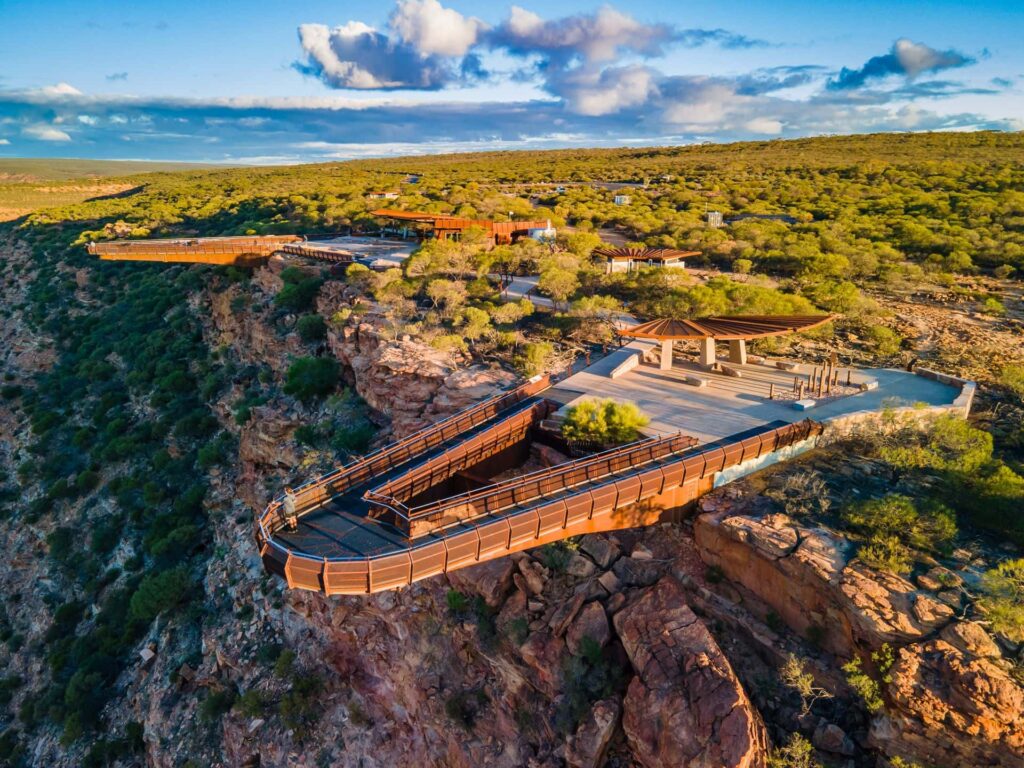 Aerial view of Kalbarri Skywalk extending over dramatic red cliffs and bushland in Kalbarri National Park, Western Australia.