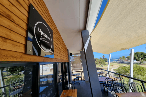 Balcony of Upstairs Restaurant in Kalbarri with ocean views and outdoor seating under sunshade.