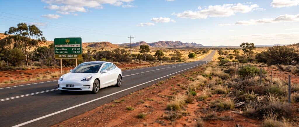 White electric vehicle driving on the open road route for EV charging Kalbarri